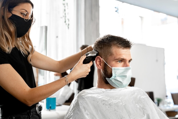 Peluquero recortando el cabello de un cliente