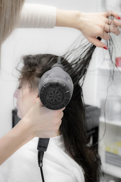 El peluquero seca el cabello de un cliente