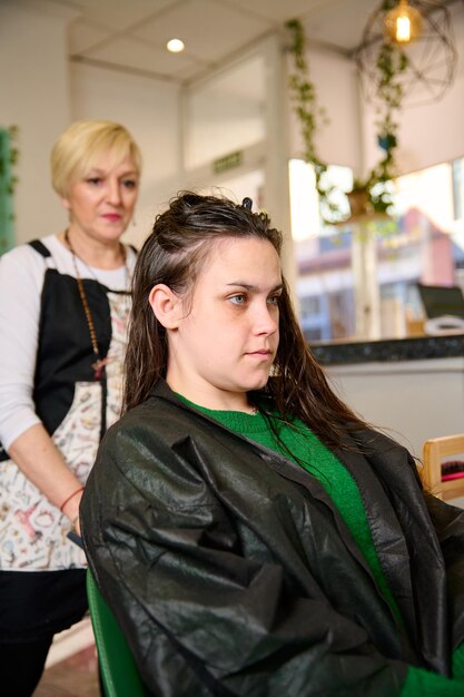 Foto el peluquero seca y peina el cabello con un secador de pelo en el salón de belleza