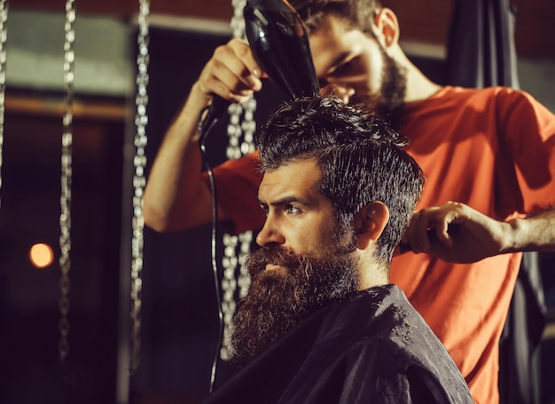 Peluquero secando el cabello al hombre