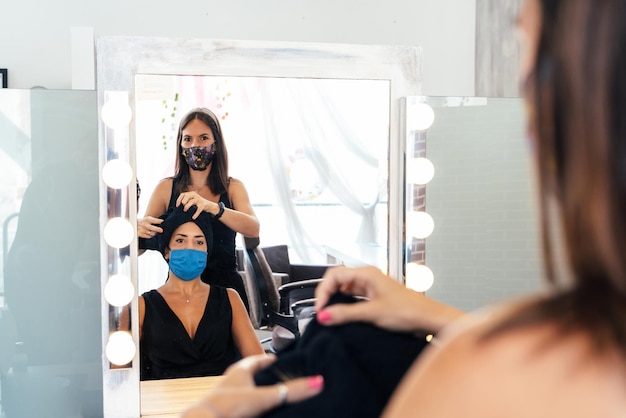 Peluquero secando el cabello de una mujer con una toalla