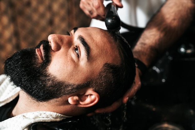 Peluquero sirviendo a un cliente en una barbería