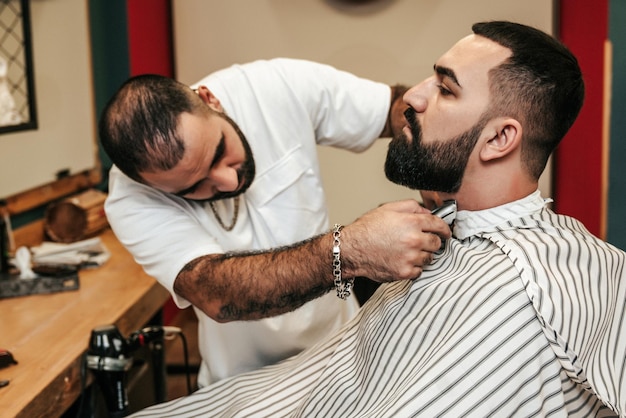 Peluquero sirviendo a un cliente en una barbería