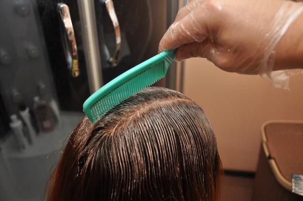 Peluquero teñiendo el cabello de un cliente