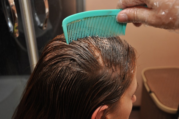 Foto peluquero teñiendo el cabello de un cliente