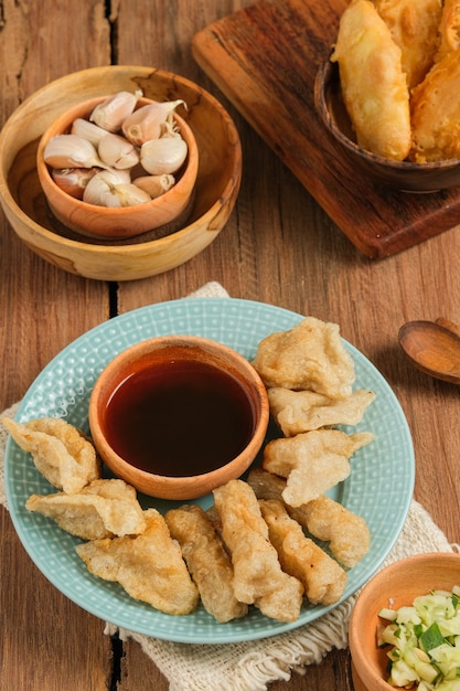 Pempek servido en mesa de madera rústica. Pempek es comida tradicional de Indonesia. hecho de pescado y tapioca servido con una rica salsa agridulce especial o salsa de vinagre llamada cuka