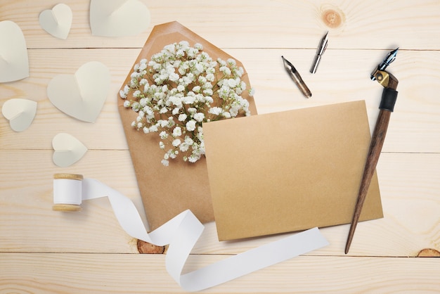 Pena caligráfica, um envelope com flores e uma carta, um cartão de felicitações para o dia dos namorados com lugar para o seu texto