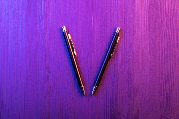 Pena dois elegante na luz de madeira e cor-de-rosa e azul. caneta preta de negócios. vista do topo