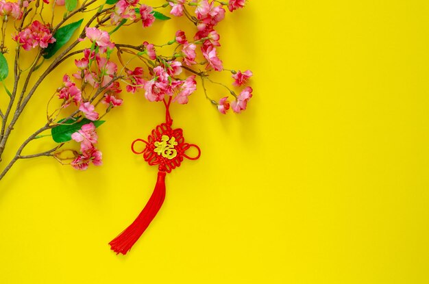 Foto pendente pendurado para ornamento de ano novo chinês significado da palavra é riqueza com flores de flores chinesas em fundo amarelo