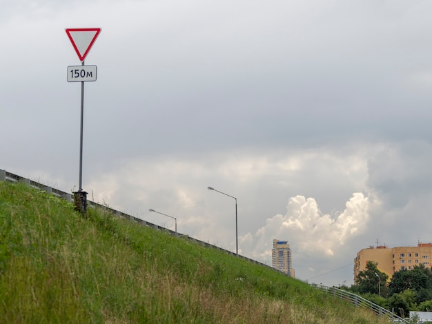 La pendiente del camino. Ceda el paso de la señal de tráfico por carretera.