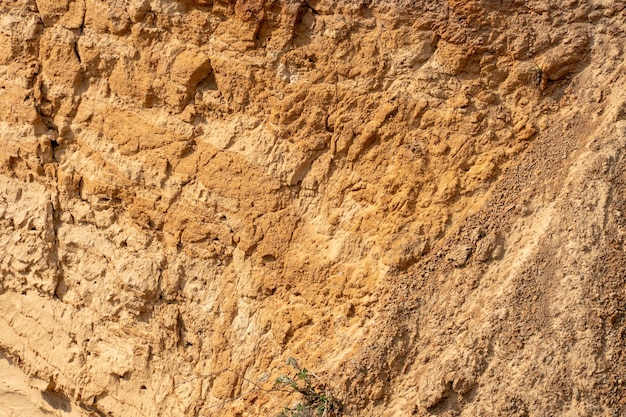 La pendiente empinada de una cantera de extracción de arena Fondo y textura de las capas de suelo de arena en una parcela del corte del suelo durante un estudio geológico