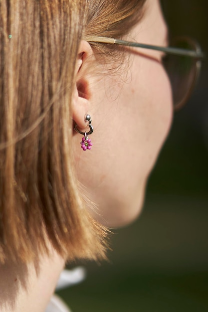 Pendientes delicados en una niña con una flor de cuentas