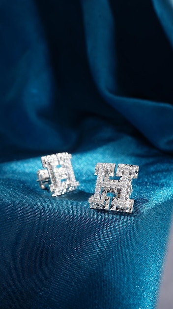 Pendientes de diamantes de oro blanco aislado sobre fondo azul.