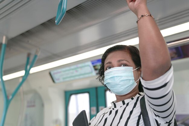 Pendlerin mit Gesichtsmaske im Zug