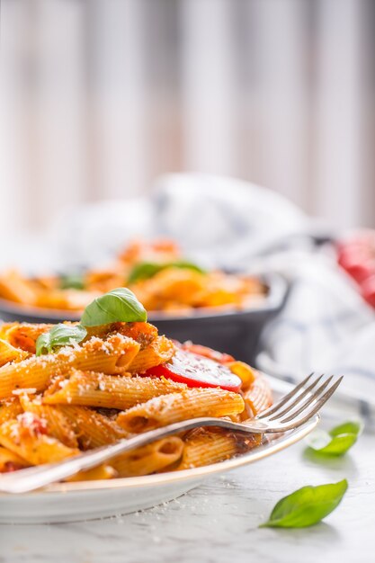 Pene de pasta y comida italiana con salsa boloñesa en un plato.