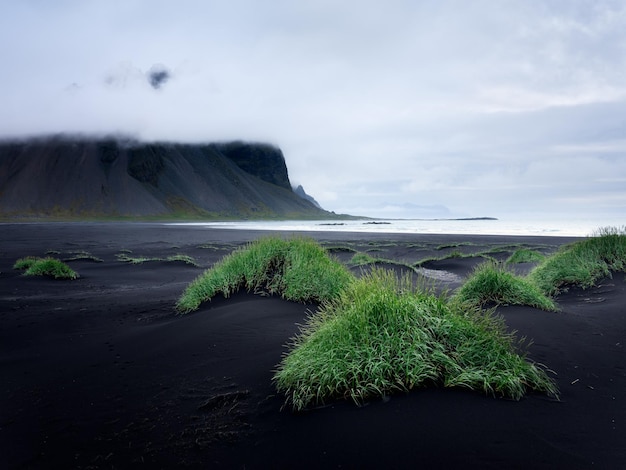 Península de Stokksnes no sudeste da Islândia Grama e areia preta na praia Paisagem natural na Islândia