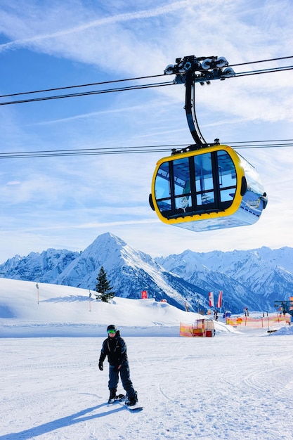 Penken, Austria - 6 de febrero de 2019: Hombres en snowboard en la estación de esquí de Penken Park en Tirol en Mayrhofen en Austria en los Alpes invernales. Snowboarder en montañas alpinas con nieve blanca. Ascensor teleférico.