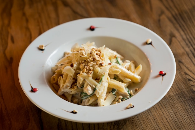 Penne com frango, espinafre e avelã em molho de parmesão