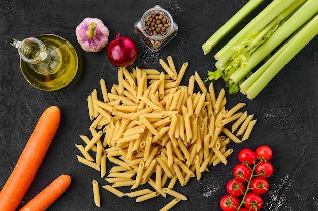 Penne crudo con ingredientes sobre una mesa