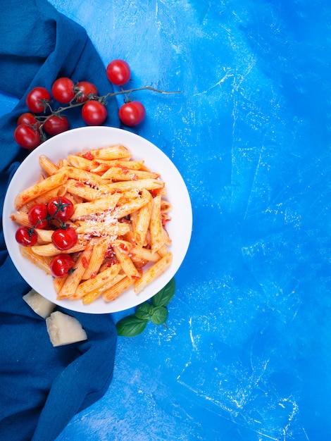 Penne de macarrão com molho de tomate, manjericão fresco, tomate assado e parmesão