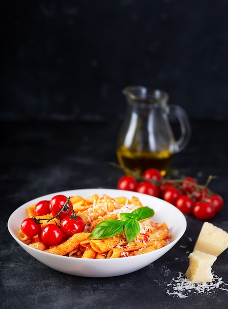 Penne de macarrão com molho de tomate, manjericão fresco, tomate assado e parmesão