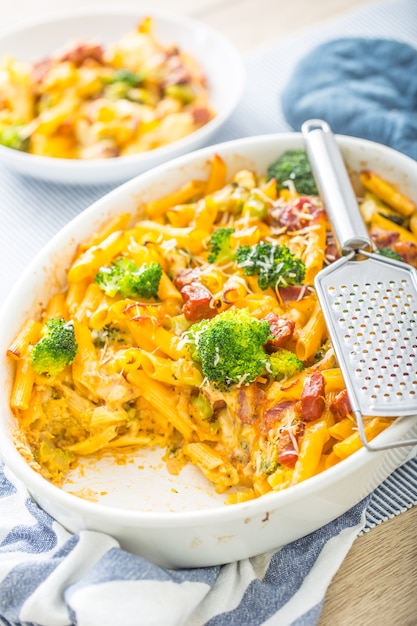 Penne de massa assada com brócolis, queijo mozzarela de porco defumado e outros ingredientes.