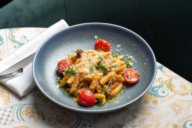 Penne de massa italiana com queijo mussarela de molho de tomate assado na mesa