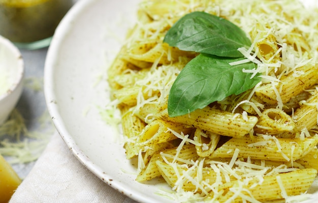 Penne-Nudeln mit Pesto-Sauce, Parmesan, Olivenöl und Basilikum