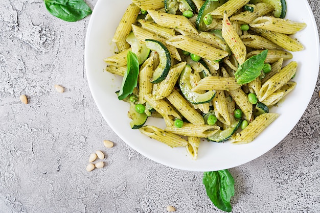 Penne Nudeln mit Pesto-Sauce, Zucchini, Erbsen und Basilikum. Italienisches Essen.