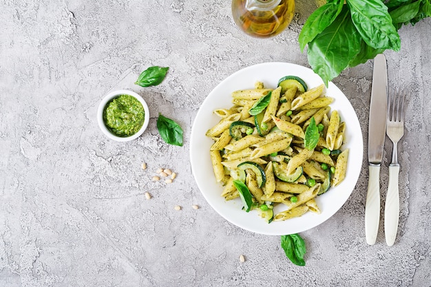 Penne Nudeln mit Pesto-Sauce, Zucchini, Erbsen und Basilikum. Italienisches Essen.