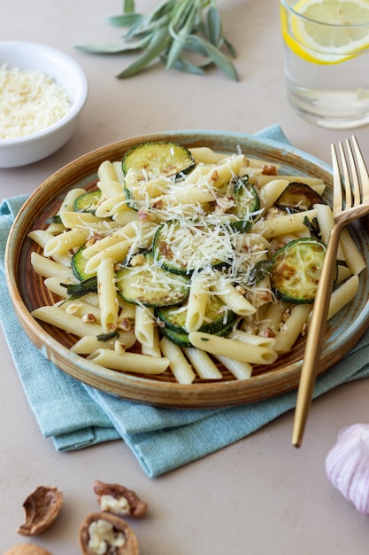 Penne-Nudeln mit Zucchini, Salbei, Nüssen und Parmesan. Gesundes Essen. Vegetarisches Essen. Italienisches Essen.