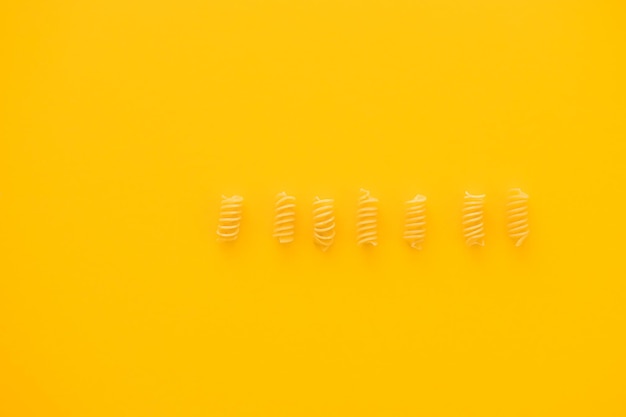 Penne de pasta aislado en amarillo desde arriba