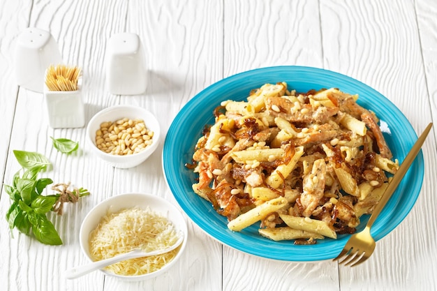 Penne de pasta alfredo de pollo con cebolla caramelizada