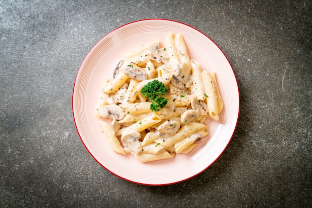 Foto penne pasta carbonara sahnesauce mit pilzen - italienische küche