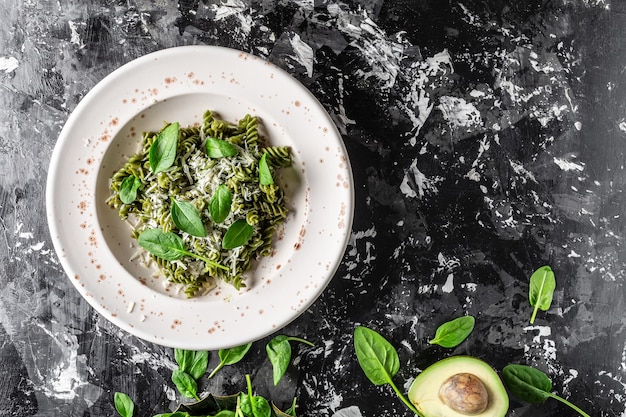 Penne Pasta mit Spinat und grünem Pesto, grüne vegane Pasta mit frischen Spinatblättern