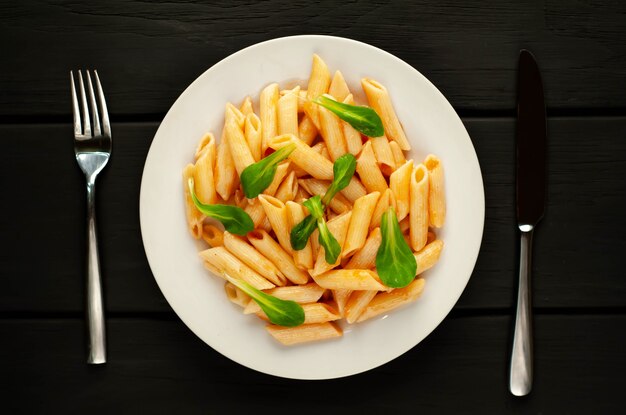 Penne pasta en placa sobre fondo de madera