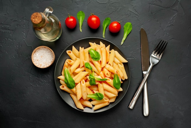 Penne pasta en un plato sobre un fondo de hormigón