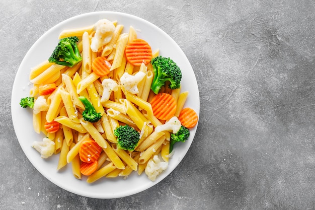 Foto penne pasta saludable con verduras en plato