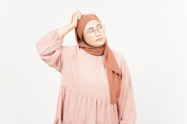 Pensamento e expressão curiosa de uma linda mulher asiática usando hijab isolado em fundo branco