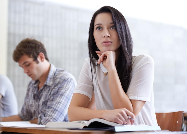 Pensamento universitário e mulher em palestra com livros para desenvolvimento em oportunidades de aprendizagem e futuro Educação conhecimento e crescimento para estudante universitário na sala de aula estudando para exame ou teste