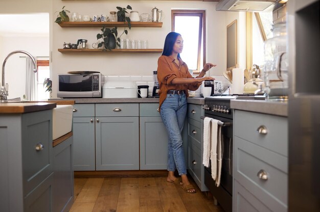 El pensamiento de la cocina y la mujer preparan café para el desayuno capuchino con leche y bebidas calientes en casa Relajación mañana tranquila y chica pensativa hacen café expreso bebida de cafeína y preparación para la paz