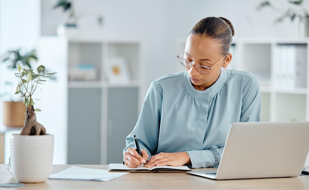 Pensamiento serio y gerente de finanzas confiado que escribe notas en un cuaderno o libro en la oficina Planificación del jefe financiero, organización y programación de plazos para impuestos o cálculo de ganancias o pérdidas comerciales