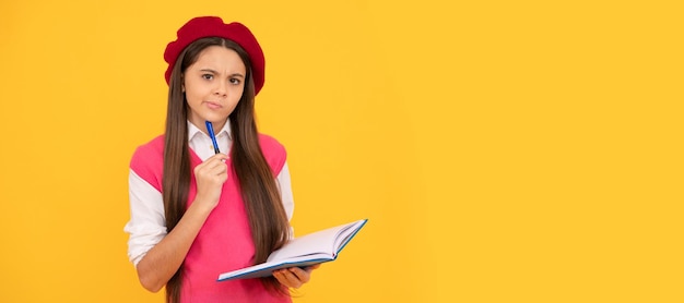 Pensando en una colegiala adolescente con boina francesa haciendo notas en el bloc de notas del planificador o en el cuaderno Banner