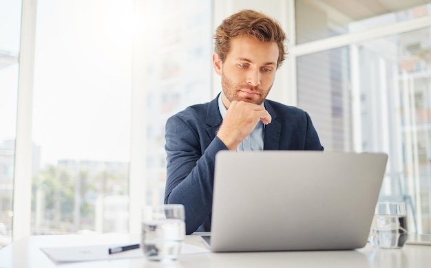 Pensando en una computadora portátil y un hombre de negocios en la oficina para enfocarse en la investigación y la planificación Tecnología de la comunicación e Internet con un empleado masculino contemplando la idea y la conexión del proyecto del sitio web