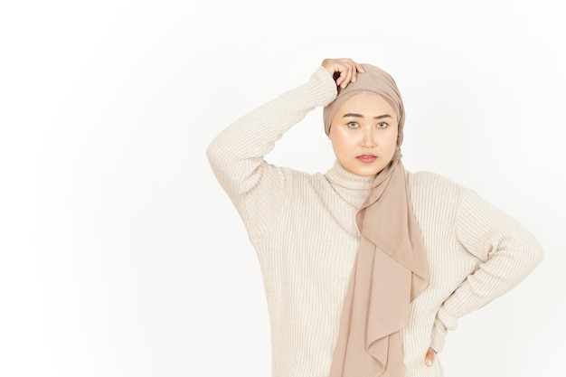 Pensando y confundido de hermosa mujer asiática vistiendo Hijab aislado sobre fondo blanco.