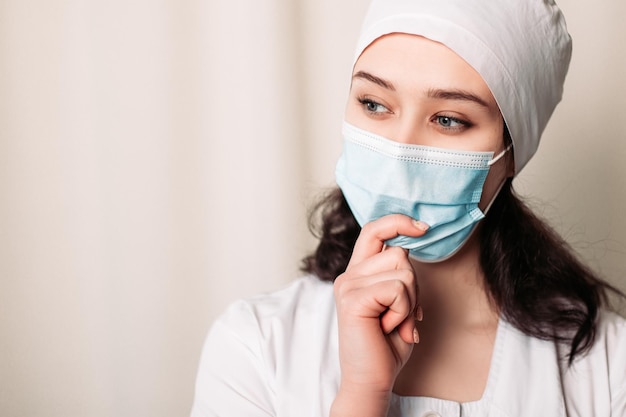 Pensando en la enfermera vestida con bata médica y usar mascarilla