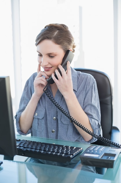 Pensando jovem mulher de negócios telefonando enquanto está sentado uma mesa