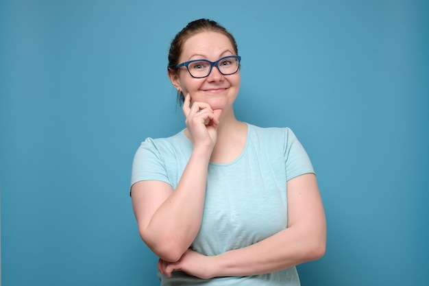 Pensando en una mujer caucásica madura con gafas pensando en hacer un plan sonriendo