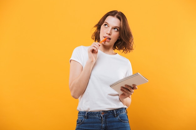 Pensando en la mujer joven escribiendo notas. Mirando a un lado.