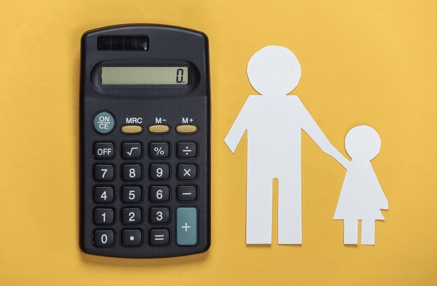 Pensão alimentícia. Família inferior. Pai e filha de papel com uma calculadora em um amarelo